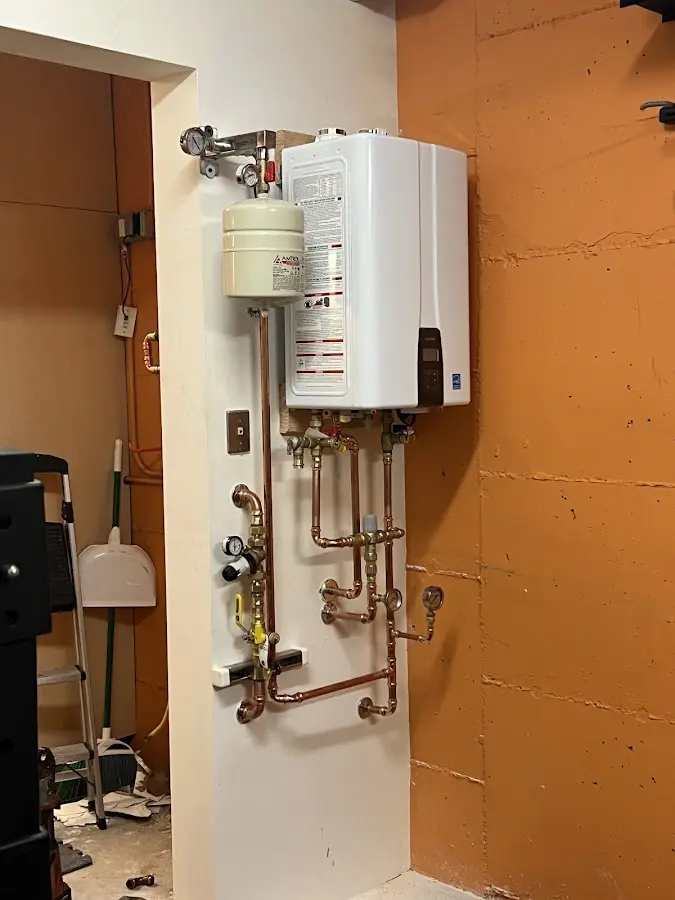 Plumbing technician inspecting water heater connections in Gillespie